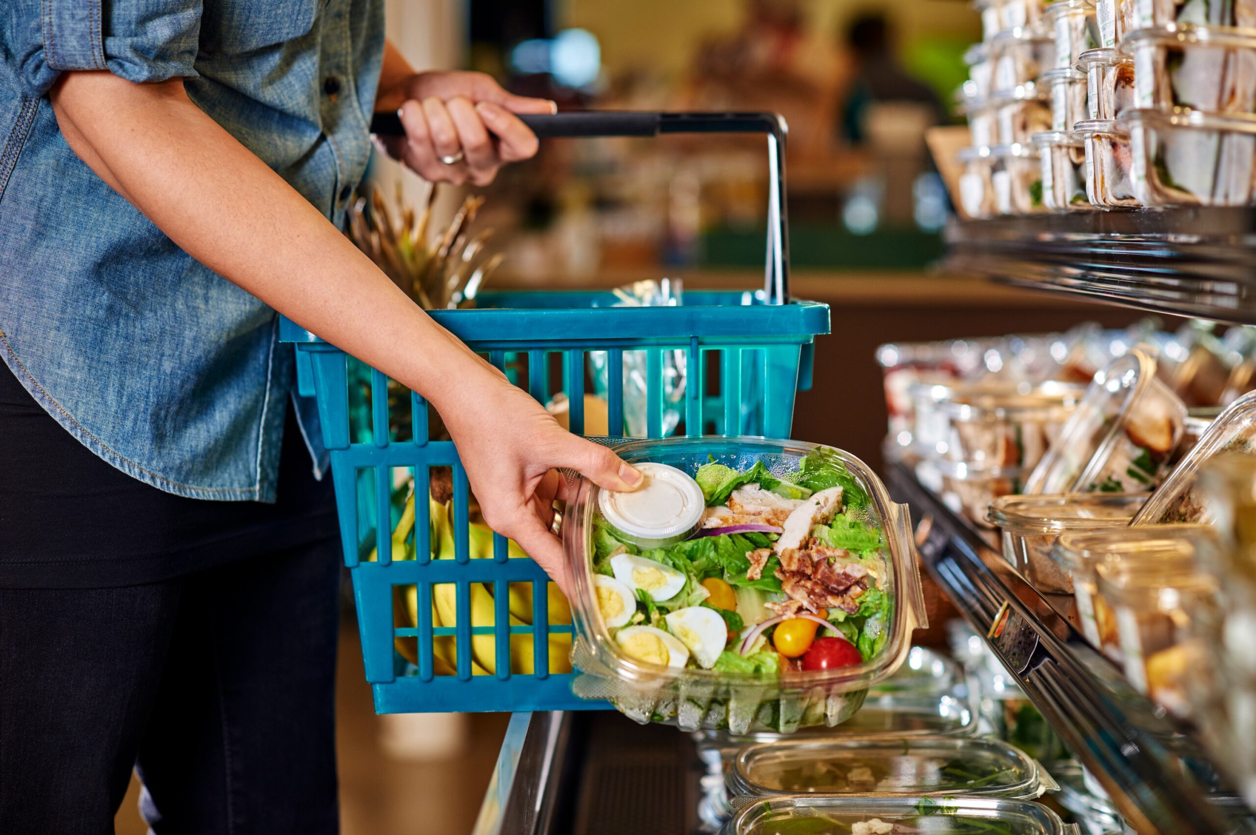 a woman buying a salad at a deli