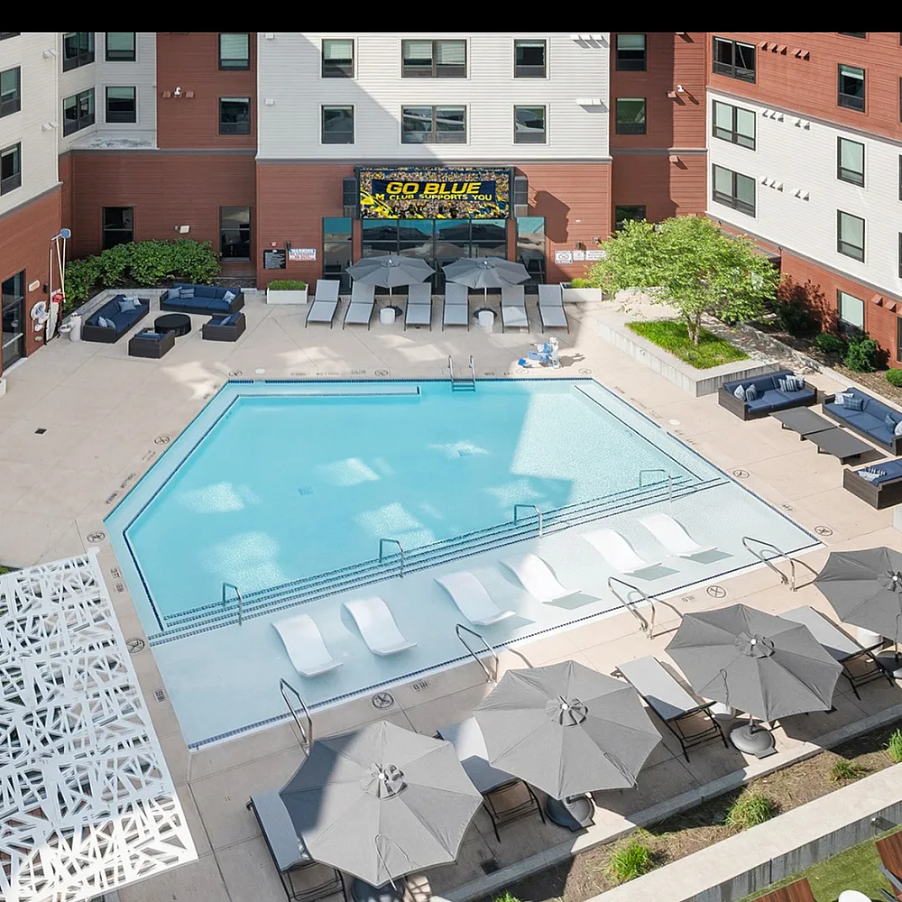 Pentagon shaped pool with luxury umbrellas and seating