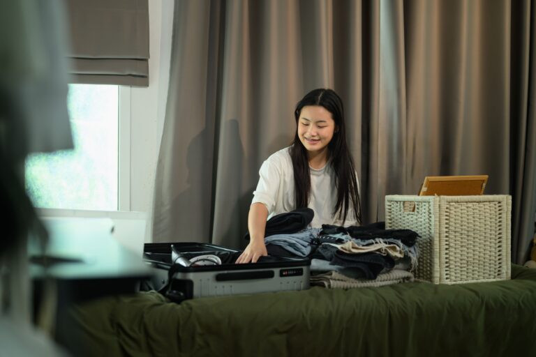 woman packing clothes into suitcase